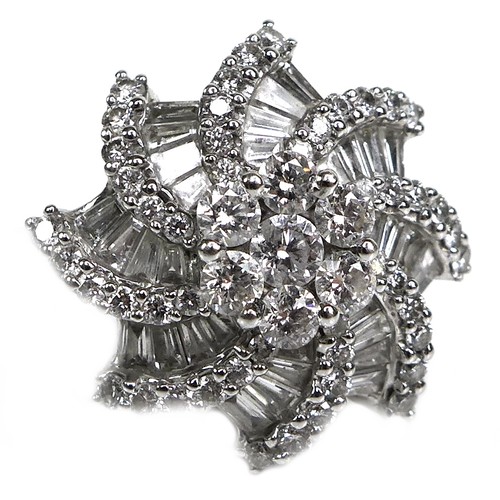 385 - An 18ct white gold and diamond flowerhead dress ring, set centrally with a flowerhead of seven round... 