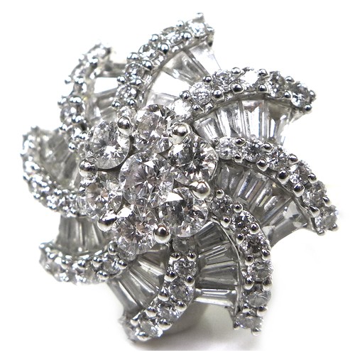 385 - An 18ct white gold and diamond flowerhead dress ring, set centrally with a flowerhead of seven round... 