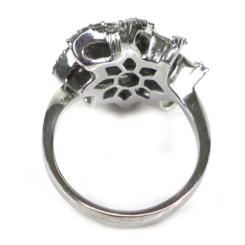 385 - An 18ct white gold and diamond flowerhead dress ring, set centrally with a flowerhead of seven round... 