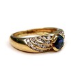 An 18ct gold sapphire and diamond ring, round cut sapphire 4mm diameter, flanked by four bands of sm... 