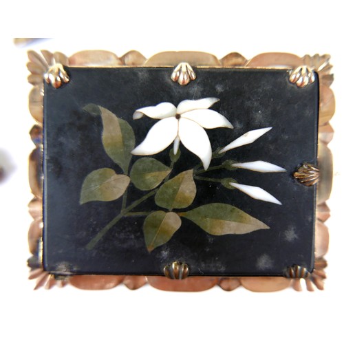 265 - An early 20th century pietra dura brooch, depicting a white lily on a rectangular slate background, ... 