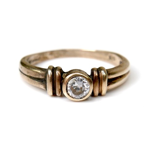 244 - A 9ct gold and white stone solitaire ring, of modern design with double banded shoulders and central... 