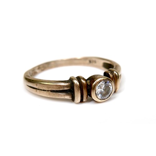 244 - A 9ct gold and white stone solitaire ring, of modern design with double banded shoulders and central... 