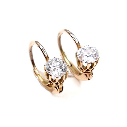 362 - A pair of diamond solitaire earrings, on fixed loop settings with hinged clasp, each brilliant cut s... 