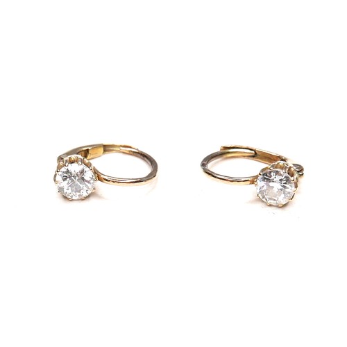 362 - A pair of diamond solitaire earrings, on fixed loop settings with hinged clasp, each brilliant cut s... 