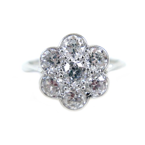 381 - A 18ct white gold and diamond flowerhead ring, set with seven round brilliant cut stones, each 3.5 b... 