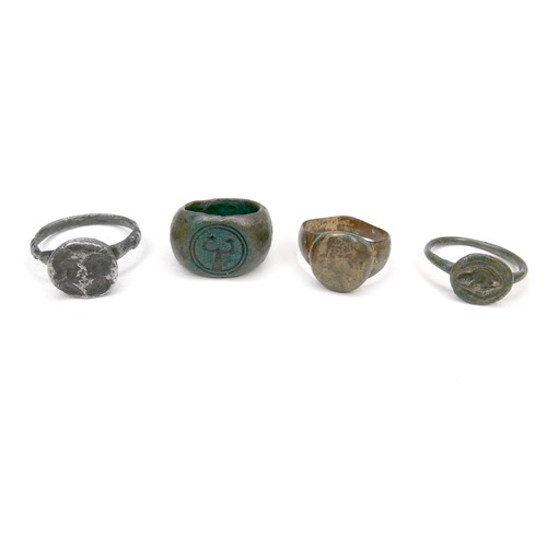 291 - A group of four ancient rings, comprising a bronze ring with early caduceus design, a signet ring of... 