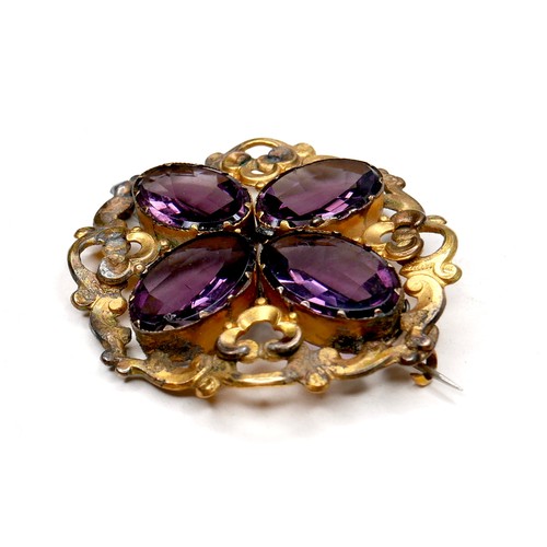 250 - A Victorian gilt brass brooch set with amethysts, the four oval stones each 18 by 12 by 6mm, and of ... 