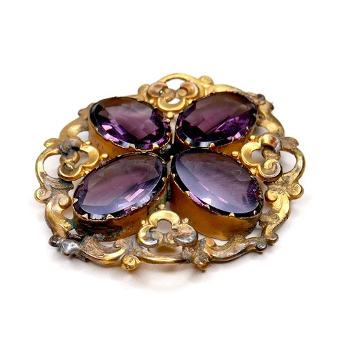 250 - A Victorian gilt brass brooch set with amethysts, the four oval stones each 18 by 12 by 6mm, and of ... 