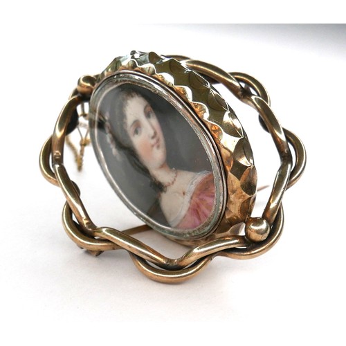 252 - An early 19th century gold framed portrait miniature brooch, depicting a girl in a pink dress, swive... 