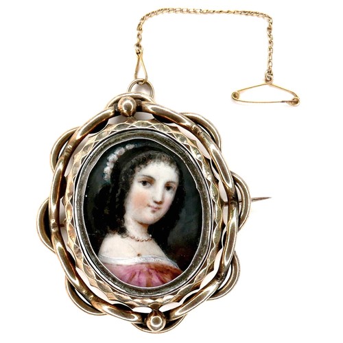 252 - An early 19th century gold framed portrait miniature brooch, depicting a girl in a pink dress, swive... 