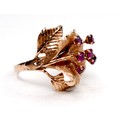 A rose gold dress ring, of flowerhead form, the stamen set with six small rubies, 2mm, marks rubbed,... 