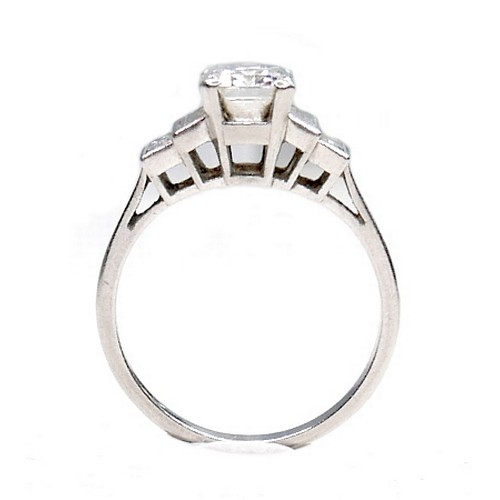 392 - An Art Deco style white gold and platinum diamond ring, the central emerald cut stone of 7.7 by 5.5 ... 