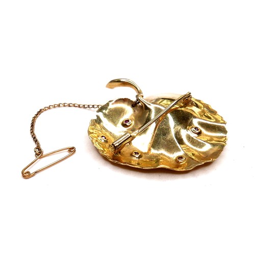 378 - An unmarked 18ct yellow gold brooch, in the form of a lily pad leaf, with chased decoration, set cen... 