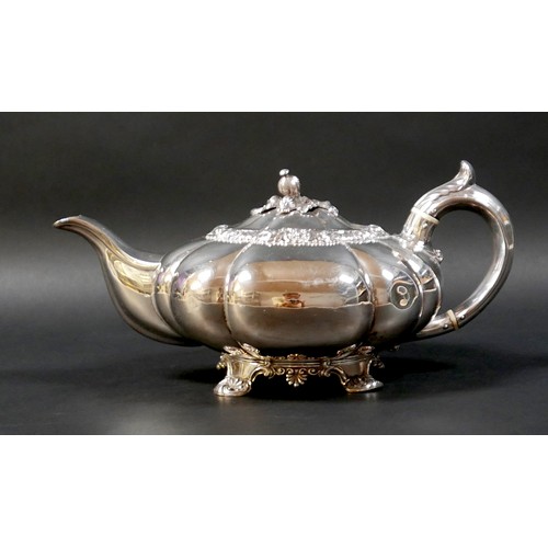 100 - A Regency silver teapot, of lobed melon form with pomegranate finial to the hinged cover, on a circu... 