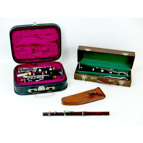 72 - Three musical instruments, comprising a cased 'A. Santoni Pare' five piece clarinet, 67cm long, a He... 