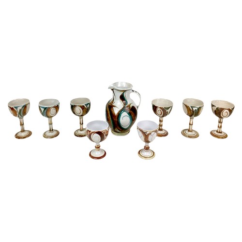 23 - A collection of Aldermaston Pottery, comprising of water jug, 25cm high, six large goblets, 17cm hig... 