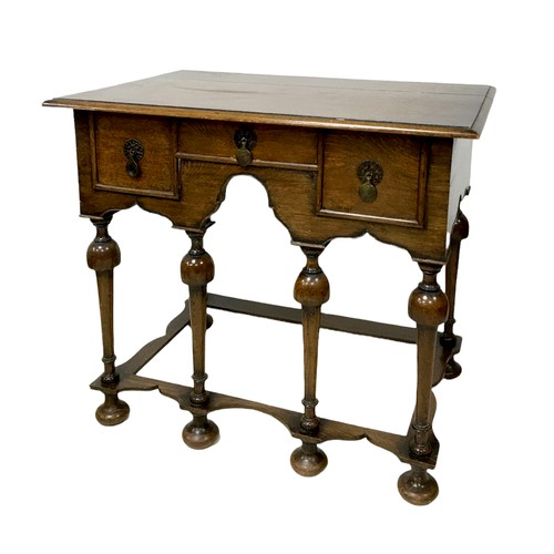 153 - A William and Mary style lowboy, with three drawers, shaped apron raised upon six turned legs with p... 