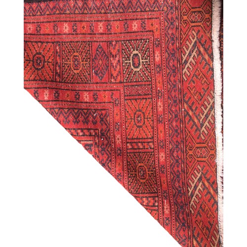 176 - A Turkman rug, red ground with twenty-four medallions to its centre, geometric patterns to its borde... 