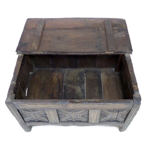 197 - A 17th century oak chest, the three panel front carved with decorative carving, raised on stile feet... 