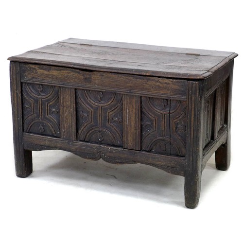 197 - A 17th century oak chest, the three panel front carved with decorative carving, raised on stile feet...