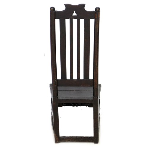 186 - A 17th century oak side chair, with ball finials and scroll crest, slat back and solid seat, raised ... 