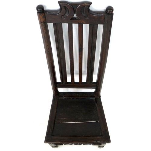 186 - A 17th century oak side chair, with ball finials and scroll crest, slat back and solid seat, raised ... 