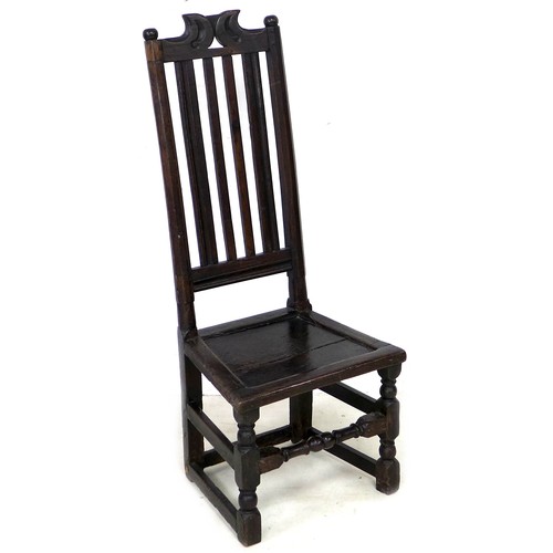 186 - A 17th century oak side chair, with ball finials and scroll crest, slat back and solid seat, raised ... 