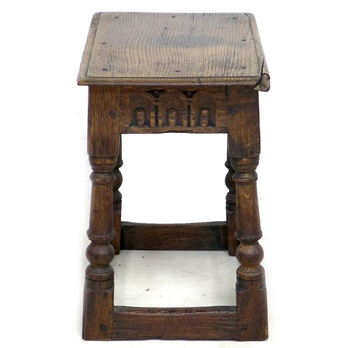 167 - An early 18th century oak stool, carved frieze, solid seat raised on turned legs joined by periphera... 