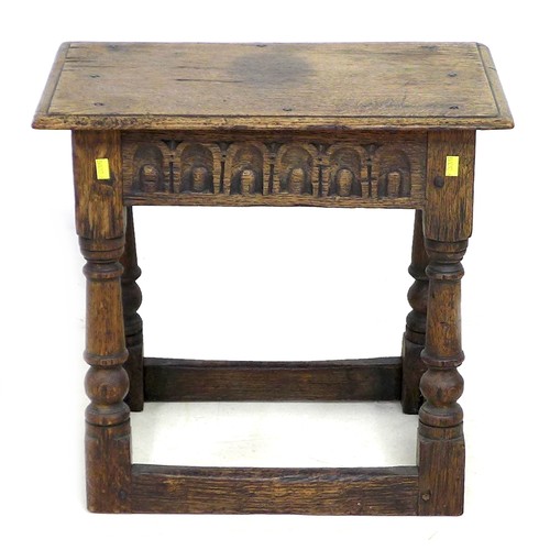 167 - An early 18th century oak stool, carved frieze, solid seat raised on turned legs joined by periphera... 