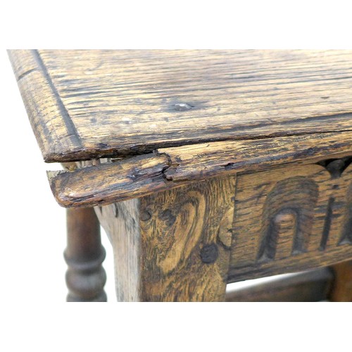 167 - An early 18th century oak stool, carved frieze, solid seat raised on turned legs joined by periphera... 