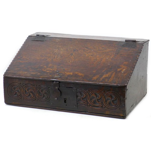 213 - A 17th century oak bible box / desk, the front carved with a continuous guilloche style frieze, iron... 