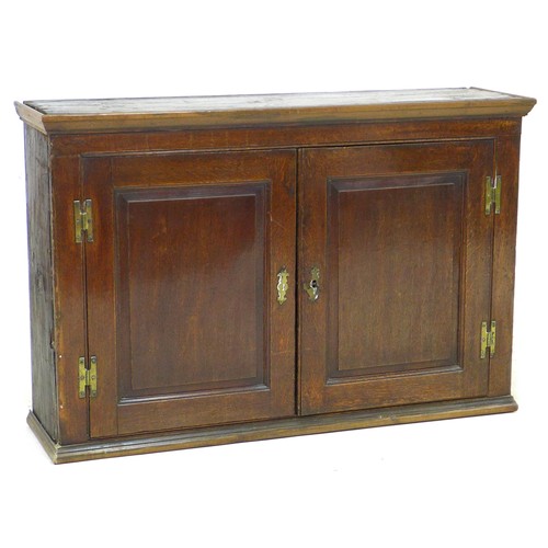 178 - An 18th century oak cupboard, with brass H hinges to twin doors enclosing two shelves, 120 by 32.5 b... 