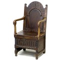 A 17th century oak Wainscot chair, the open arms with scroll carved ends, lift lid to box seat with ... 