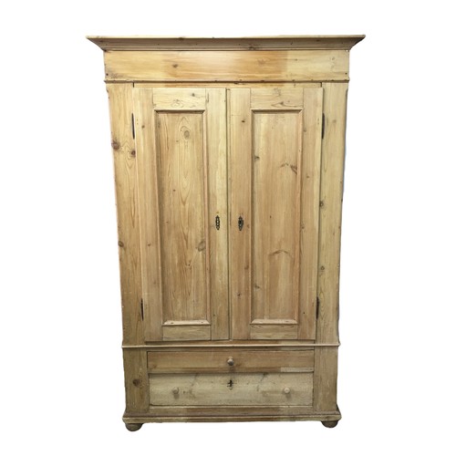 190 - A Victorian pine double door wardrobe, with two drawers to its base, raised upon bun feet, 111.5 by ... 