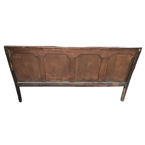 206 - A George III oak settle, with four fielded panels, open shaped arms, replacement seat, raised on squ... 