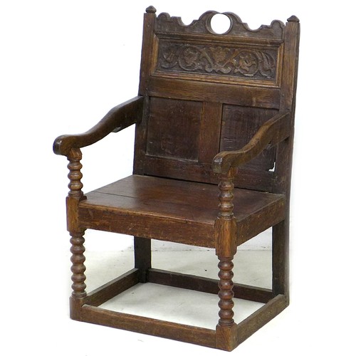 202 - A late 17th century oak Wainscot chair, with open shaped arms, later solid seat, three panel back, t... 