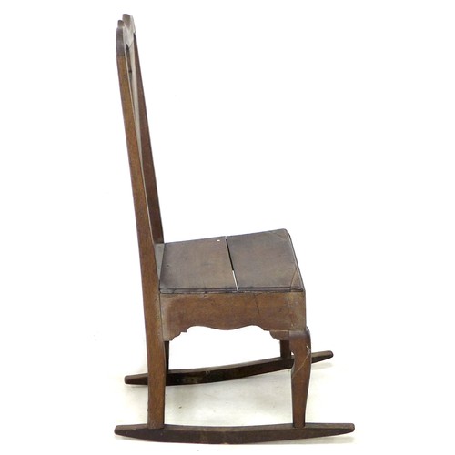 165 - An 18th century oak rocking chair, with shaped top rail, urn form back slat, solid seat, raised upon... 