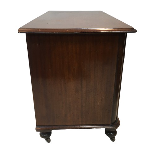 154 - An early 20th century mahogany chest of two over two drawers, with turned legs raised upon casters, ... 