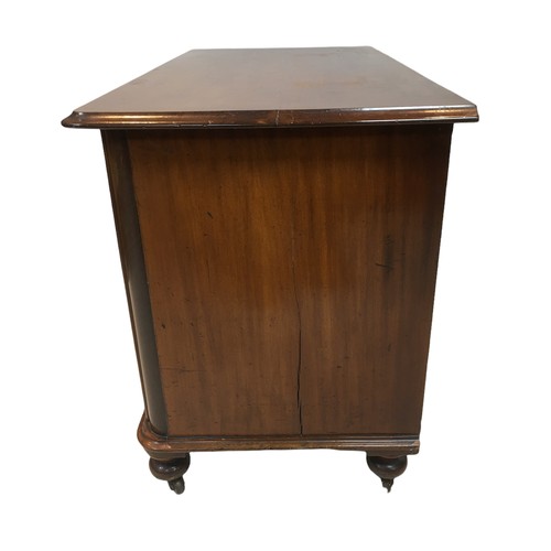 154 - An early 20th century mahogany chest of two over two drawers, with turned legs raised upon casters, ... 