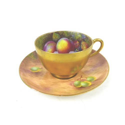 43 - A Royal Worcester tea cup and saucer, painted with fruit to a mossy ground, the cup painted on the i... 