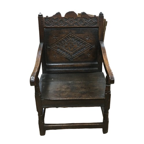 211 - A 17th century oak Wainscot chair, with open scroll end arms, later solid seat, single panel back ca... 