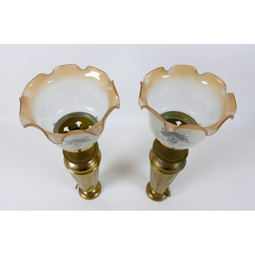 37 - A pair of Art Nouveau brass table lamp bases, with embossed floral decoration, frosted glass shades ... 