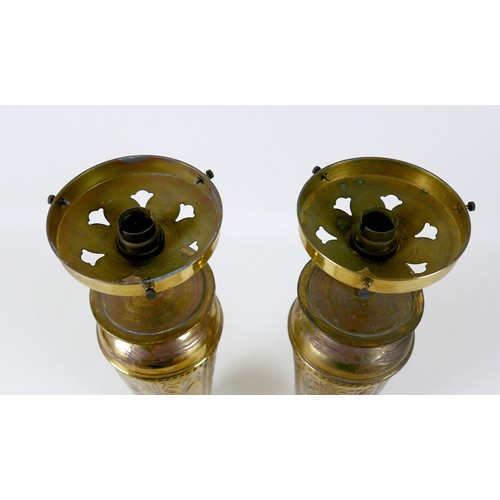 37 - A pair of Art Nouveau brass table lamp bases, with embossed floral decoration, frosted glass shades ... 