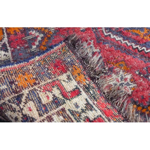 162 - Two mid 20th century rugs, comprising a  with red ground woollen rug with ten circular lozenges to i... 