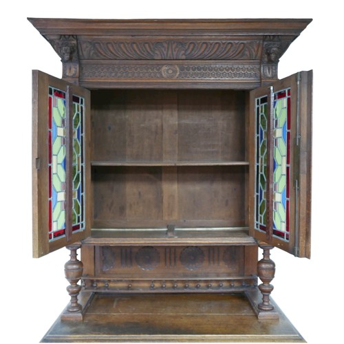 186 - A Flemish 19th century carved oak cabinet, with carved cornice and lions head mounts, the top sectio... 