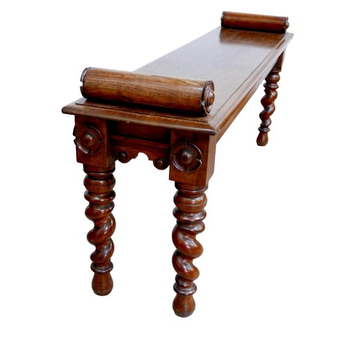 176 - An early 20th century oak window seat, with carved  decoration to its cylindrical arms, raised upon ... 