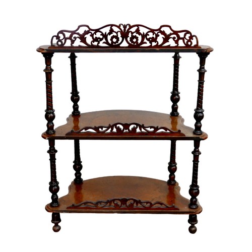 150 - An early 20th century three tiered walnut whatnot, with pierced foliate decoration, turned supports ... 