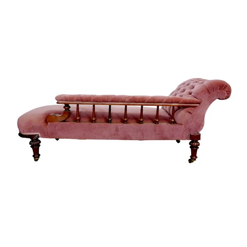 173 - An Edwardian chaise longue, with mahogany frame and pink upholstery, button back, raised upon turned... 