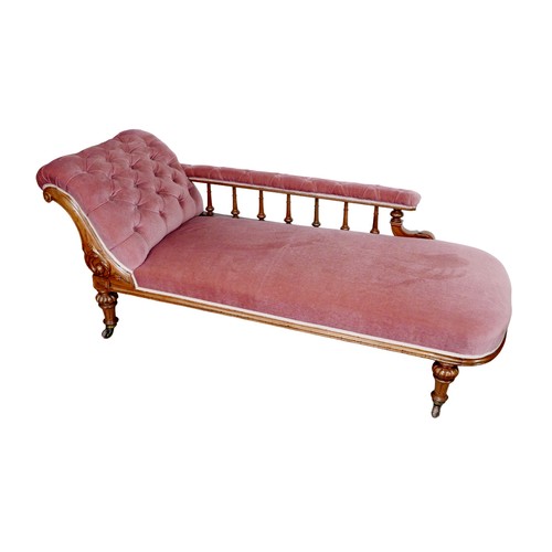 173 - An Edwardian chaise longue, with mahogany frame and pink upholstery, button back, raised upon turned... 